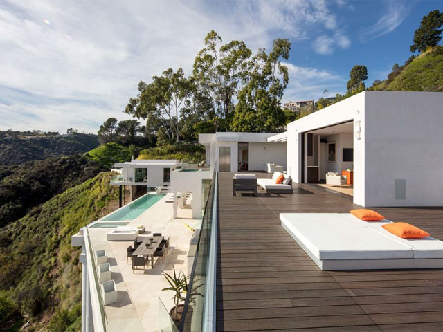 Modern hillside home with stucco exterior finish and outdoor living area in Los Angeles